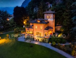 Villa on Lake Como by night with boathouse and wide park